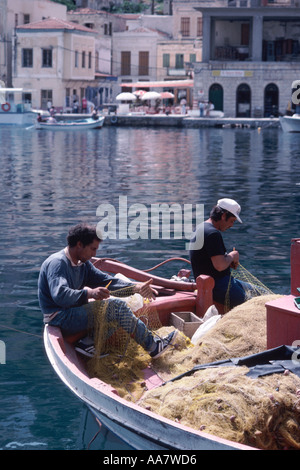 Fischer ausbessern Netze im Hafen von Symi, Dodekanes, in der Nähe von Rhodos, Griechenland Stockfoto