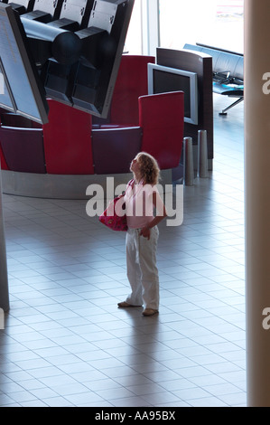 Reisende auf der Suche auf der Anzeigentafel in einem leeren Flughafen Stockfoto