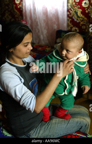 EINE JUNGE ROMA-MUTTER MIT IHREM BABY AUF EINE ROMA-ZIGEUNER-STANDORT IN DER NÄHE KOSICE SLOWAKEI IM JAHR 2004 Stockfoto