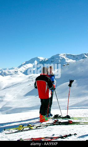 Zwei männliche Skifahrer aus ihre Skier mit einem Chat an den Hängen des St. Moritz Skigebiet der Schweiz Stockfoto