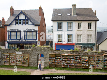 Shopper mit Bücher für den Verkauf auf Outdoor-Regale im Innenhof Burg Hay on Wye Wales UK Stockfoto