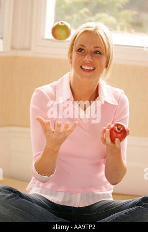 Mädchen, die Äpfel jonglieren Stockfoto