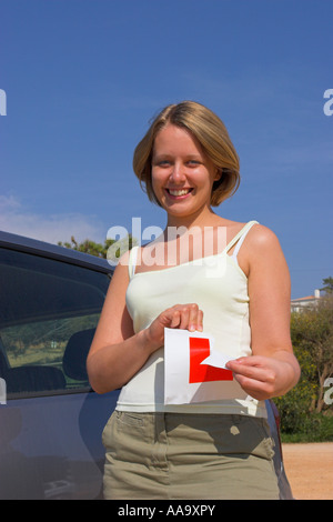 Junge Frau zerreißt ihr L-Platte nach bestandener Fahrprüfung. Stockfoto