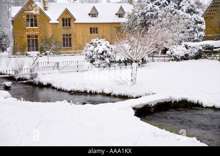 Winterschnee auf einem alten Bauernhaus am River Eye Im Cotswold Dorf Upper Slaughter Gloucestershire Großbritannien Stockfoto