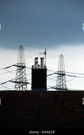 Schornstein eines Hauses mit Hochspannungsmasten Strom aus dem Kernkraftwerk in Sizewell, Suffolk, UK. Stockfoto