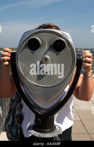 Frau, die durch ein Münz-Fernglas auf der Spitze der Mole St. Petersburg, Florida Vereinigte Staat usa Stockfoto