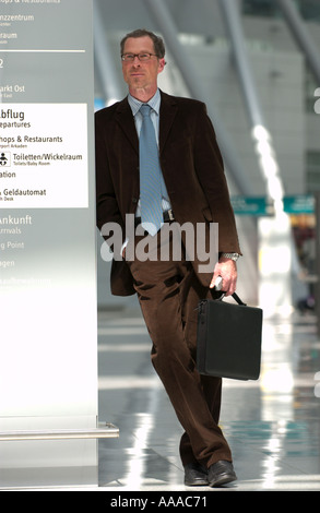 Mann in seinen Vierzigern in einem Business-Anzug warten in der Lobby eines Flughafens Stockfoto