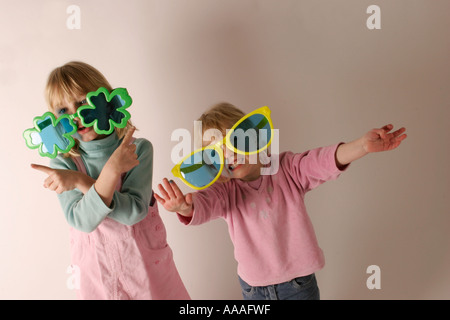 Schwestern in Sonnenbrillen Kinder Spaß spielerisch über Hanteln Stockfoto