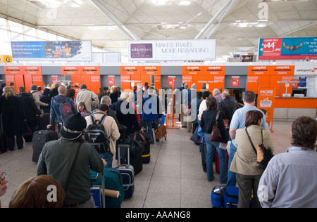 Menschen in die Warteschlange für den Check-in am Easyjet-Schalter Stansted Flughafen England Großbritannien Uk Stockfoto