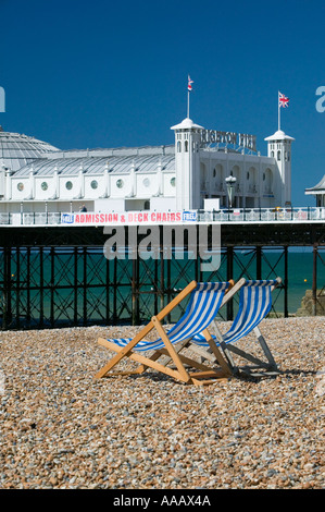 Zwei Liegestühle am menschenleeren Strand Palace Pier Brighton UK Stockfoto