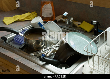 als Haufen von schmutzigem Geschirr in einer Küchenspüle Stockfoto