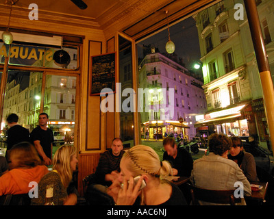 Innenraum einer belebten Café le Progres mit Montmartre in der Nacht durch das Windows Montmartre Paris Frankreich Nachtleben gesehen Stockfoto