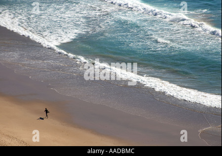 Einsamer Surfer auf einer einsamen Strand-Szene, Praia da Amado, Algarve, Portugal Stockfoto