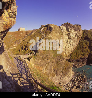 Küsten Blick auf eingezäunten Weg entlang am Abend sonnenbeschienene dramatischen Klippen und Fußgängerbrücke an der Tintagel Castle Cornwall in England Stockfoto