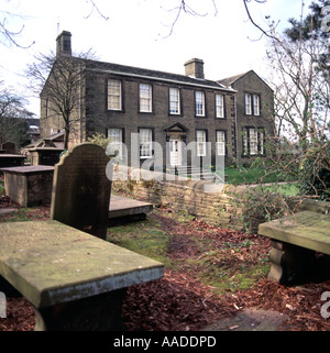 Haworth-Kirchengruft und Grabsteine mit historischem Brontë-Familienwohnheim und jetzt Bildungsmuseum in West Yorkshire England Stockfoto
