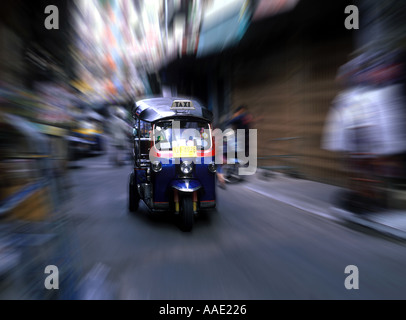 Beschleunigung Bangkok Tuk Tuk Taxi Reisen durch eine schmale Gasse in der Blume Markt Viertel von Bangkok, Thailand Stockfoto