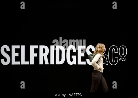 Junge Frau geht vorbei an Selfridges Store auf der Oxford Street in London Stockfoto