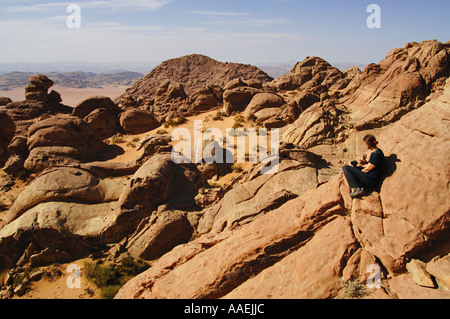 Trekker bewundert ein Panorama von einem einsamen Gipfel in Wadi Rum Protected Area Jordan Stockfoto