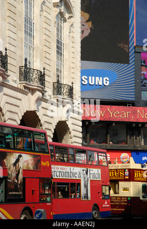 Londoner Busse vorbei an den berühmten riesigen Neon Werbebildschirm in Piccadilly Circus-London England Stockfoto