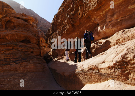 Beduinenführer und Besucher erkunden eine Schlucht im Wadi Rum Protected Area Jordan Stockfoto