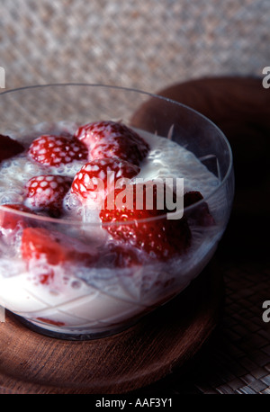 A glass bowl of strawberries in cream Stockfoto