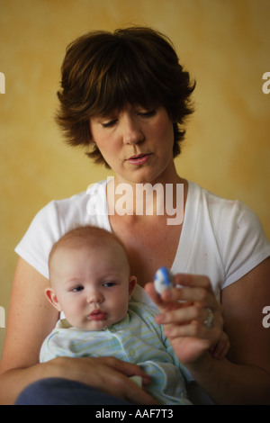 Mutter nehmen Temperatur des Kranken 6 Monate altes Babyjungen Stockfoto