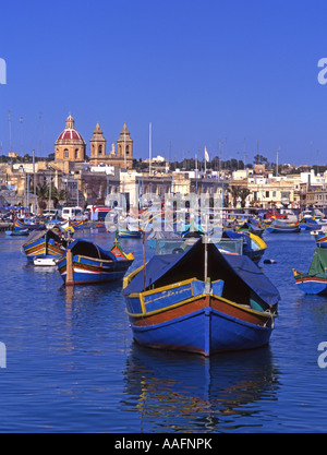 Marsaxlokk, Malta. Hafen und Kirche. Typische maltesische Luzzu (Fischerboote) Stockfoto