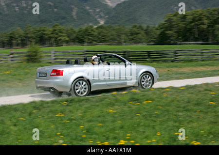 Eine ältere Frau Cabriolet Sportwagen mit Dach hinunter fahren Stockfoto