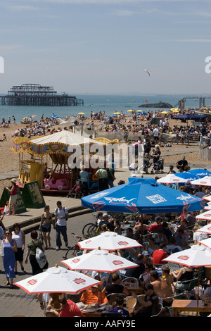 Massen von Urlaubern am Strand von Brighton. Pier West im Hintergrund. Stockfoto