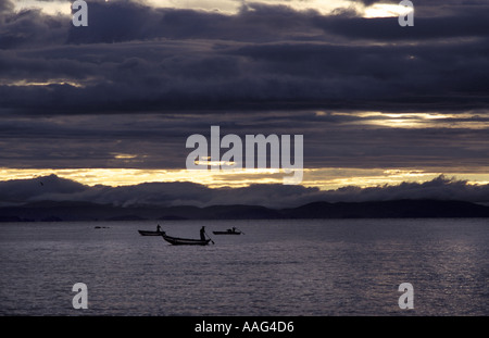 Angelboote/Fischerboote aus Insel Taquile auf dem Titicacasee bei Sonnenaufgang Wolken Hüllen der peruanischen Festland Amantani Peru S America Stockfoto