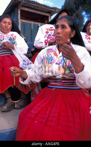 Freundliche Frauen aus Amantani im markanten tribal Kostüm Spinnen Wolle Amantani Island Lake Titicaca Peru Südamerika Stockfoto