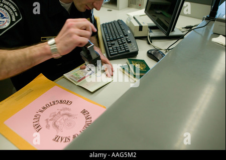 Customs and Border Protection Officer in einheitlicher Briefmarken Pass für ankommende Passagiere am Flughafen JFK, New York City, April 2006 Stockfoto