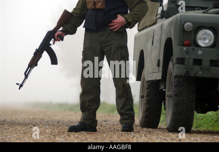 ein Terrorist, gekleidet in eine Sturmhaube hält eine AK47 Kalaschnikow und tragen eines Gürtels von Kugeln neben einem Land rover Stockfoto