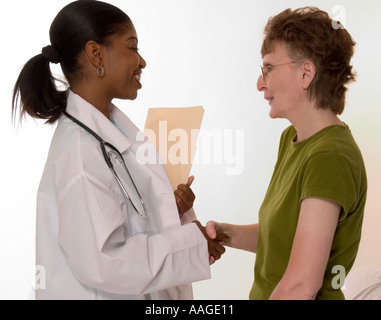 GP Lächelnd schüttelt Hände mit weiblichen Patienten nach guten Bericht. USA Stockfoto