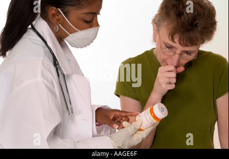 Afroamerikaner Arzt diskutiert verschreibungspflichtige Medikamente mit einer kaukasischen Patientin während der Konsultation, USA. Stockfoto