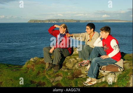 eine Mutter mit ihren Söhnen, genießen die Aussicht vom Insel Carrick-a-Rede in der Grafschaft Antrim in Nordirland nach Rathlin Island Stockfoto