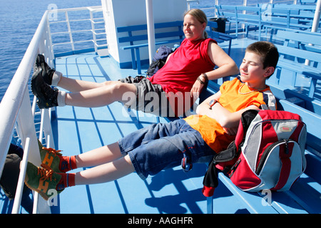 eine Frau und ein Junge in der Sonne liegen auf der Fähre von Hora Sfakion nach Agia Roumeli Stockfoto