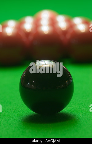 Schwarze Kugel auf dem grünen Filz ein Snooker-Tisch mit den Reds zerbrach im Hintergrund UK Stockfoto