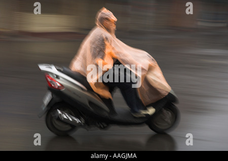 Vietnam Hanoi Old Quarter Leute Reiten auf 2 Rädern bei nassem Wetter mit Nylon Schutz junger Mann Reiten gemoppt Stockfoto
