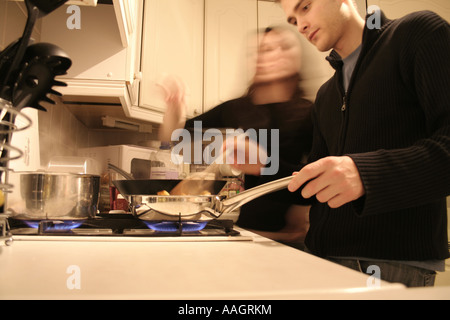 Paar, Kochen in der Küche mit Wok auf Gas-Kochfeld Stockfoto