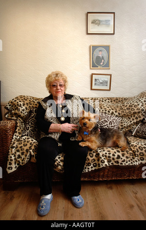 EINE WEIBLICHE RENTNER MIT EINEM LEOPARD SKIN SOFA UND WESTE WALES UK Stockfoto