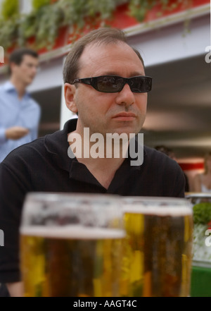 zwei Gläser Bier im Vordergrund mit Mann mit Sonnenbrille Stockfoto