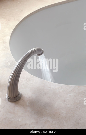 Ovale Spüle Badewanne mit silbernen Hahn fließt Wasser Stockfoto