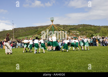 Kinder von der örtlichen Grundschule Tanz um den Maibaum am MayDay fair Woodmancote Gloucesterhire UK Stockfoto