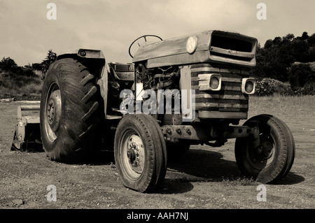 Alte rostige Traktor in einem Feld-sepia Stockfoto