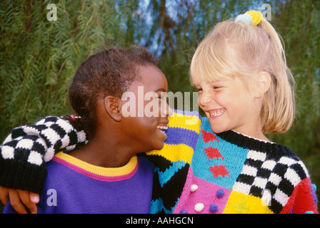 Mädchen 6 7 jährige mit Arm um Freund lächelnd auf Regentag ethnisch ethnische Vielfalt multikulturellen Multi kulturelle Herr © Myrleen Pearson Stockfoto