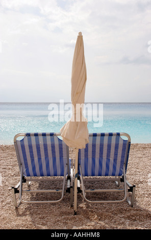 Sonnenschirm und zwei Liegestühle am Porto Katsiki auf der griechischen Insel Lefkas Stockfoto