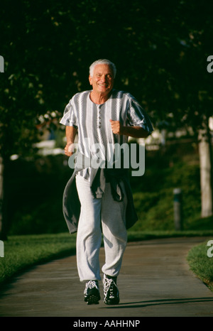 Eine lächelnde ältere Mann Bürger männlich 73 Jahre alte Ausübung Übung Energie energetische Sonne Brille Sonnenbrille im Park grüne textfreiraum POV Herr laufen Stockfoto