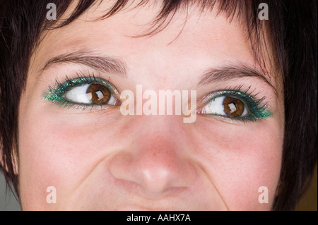 junge Frau zwanziger Jahre glücklich lächelnd zu vertrauen Glanz leuchten positive Kameraaugen hautnah Stockfoto