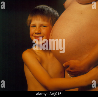 junge/Mädchen hören auf den Bauch seiner schwangeren Mutter-Foto von Willy Matheisl Stockfoto